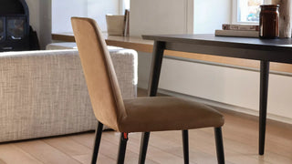 Photo d'ambiance d'une chaise Mobitec Rob cognac à pieds noirs à une table noire près d'un canapé
