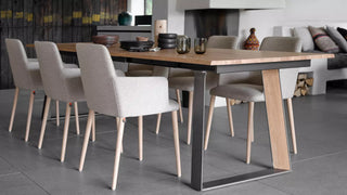 Photo d'ambiance de chaises à accoudoirs Mobitec Rob crème autour d'une longue table en bois dans un loft