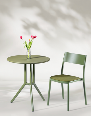 Sfeerbeeld van een olijfgroene Gaber To-Me stoel bij een ronde bistrotafel met tulpen