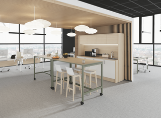 Lifestyle image of the Buronomic Nuanza mobile high table with white stools in an open kitchen