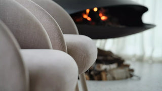 Detail of ecru Mobitec Thalia armchairs by a fireplace