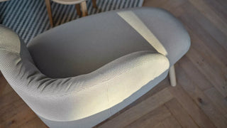 Detail of a grey Mobitec Thalia armchair on herringbone parquet, top view