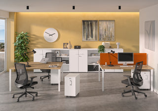 Lifestyle image of a white Buronomic Comfort slim pedestal by workstations with orange screens