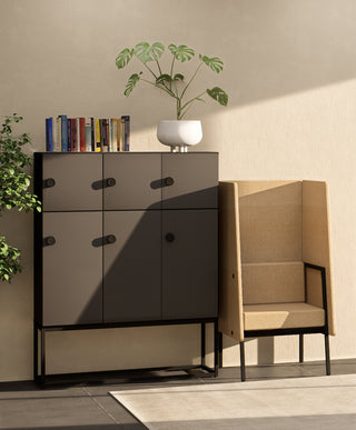 Sfeerbeeld van een zwarte Buronomic Locker Eko kast met negen vakken naast een beige fauteuil