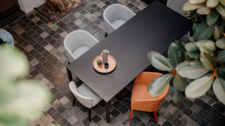 Lifestyle image of grey and orange Mobitec Cuori chairs at a dark table, top view